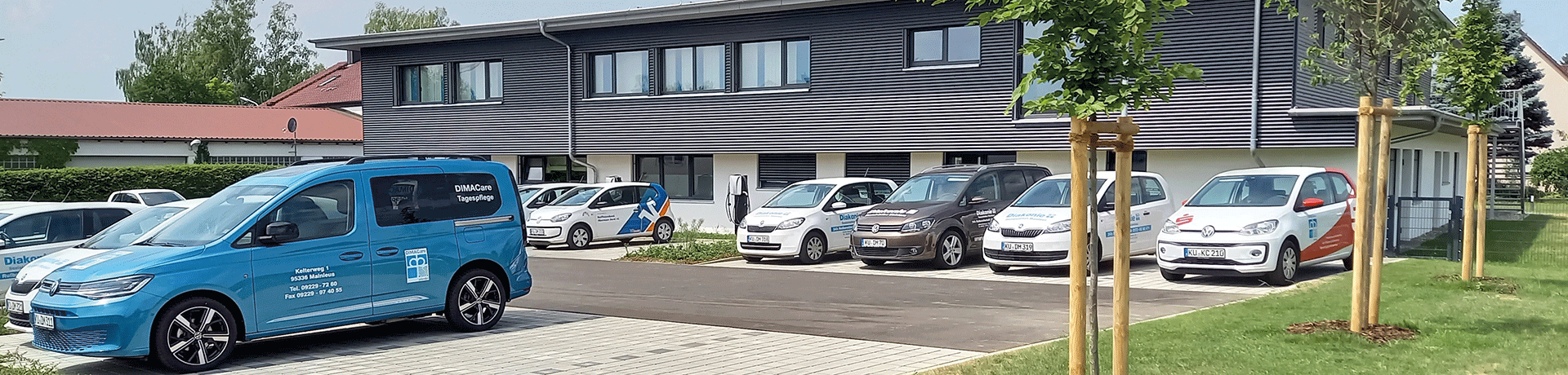 Parkplatz vor dem Gebäude mit Autos der Diakonie